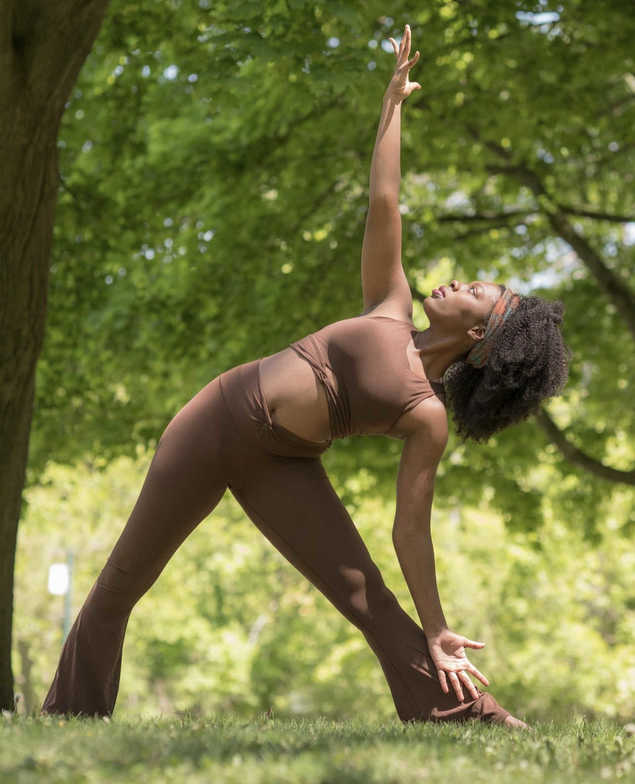 women with an afro doing yoga in the park