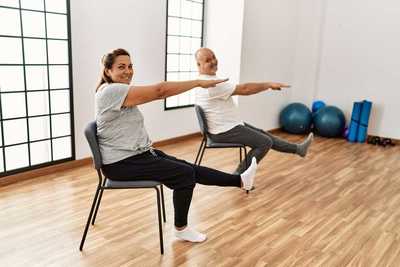 chair yoga with women in grey and man in white